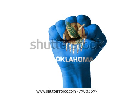 Low key picture of a fist painted in colors of american state flag of oklahoma