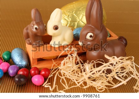Various colors and shaped easter eggs and bunnies on a gold background