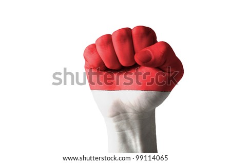 Low key picture of a fist painted in colors of indonesia flag