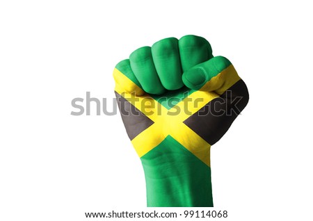 Low key picture of a fist painted in colors of jamaica flag