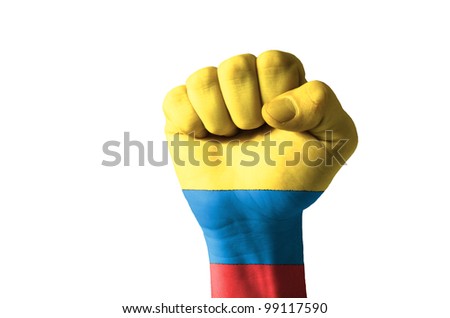 Low key picture of a fist painted in colors of colombia flag