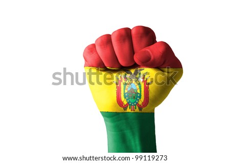 Low key picture of a fist painted in colors of bolivian flag