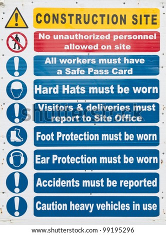 construction site sign with safety notices hanging on a wooden wall