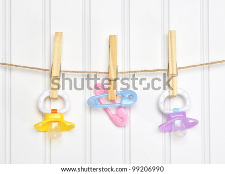 Baby Pacifier Binky Pink on a Clothesline on White. Royalty-Free Stock Photo #99206990