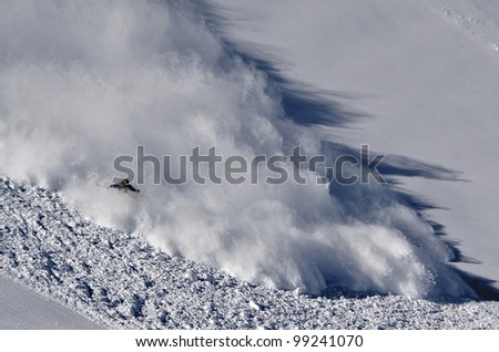 Skier riding the avalanche Royalty-Free Stock Photo #99241070