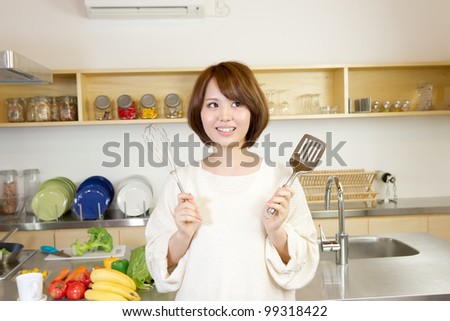 Beautiful woman standing in kitchen. Portrait of asian woman.