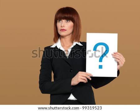 portrait of a beautiful, young, businesswoman, holding a sheet of paper with a question mark sign, on beige background