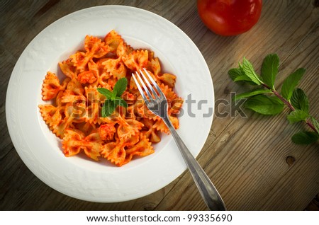 Farfalle pasta seasoned with tomato sauce and shrimps
