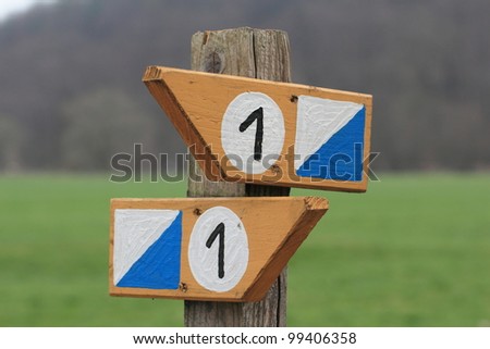 a wooden direction sign with the number one