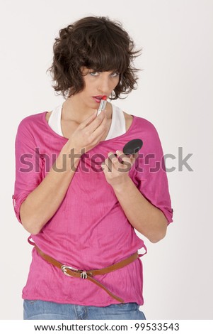young woman in pink shirt paints her lips /fashionable woman with lips make-up
