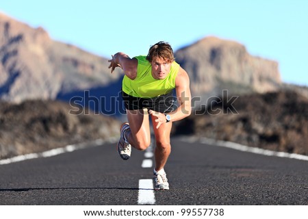 Sprinter. Man running on road at high speed in beautiful exotic mountain landscape. Male athlete runner in intense sprint during outdoor workout Royalty-Free Stock Photo #99557738