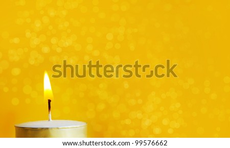 One Burning candle in a yellow background