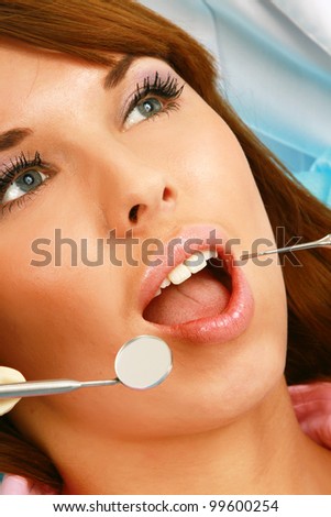 A dentist is treating teeth of the patient , isolated on white background