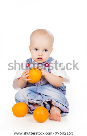 a studio portrait of a nice little child holding an orange in his hand