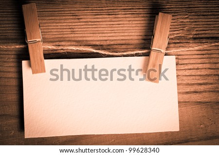 clothespin with blank white card on the wooden backgorund