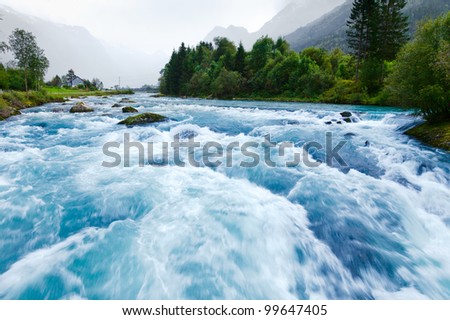 Milky blue glacial water of Briksdal River in Norway Royalty-Free Stock Photo #99647405