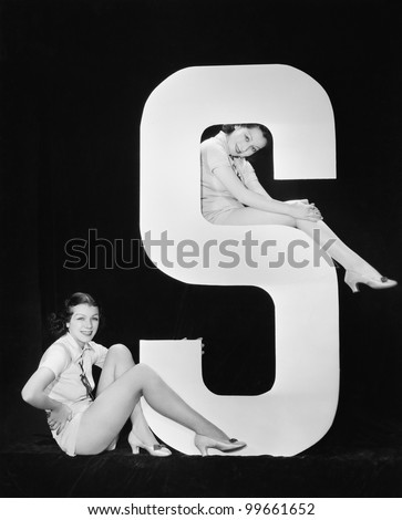 Women posing with huge letter S