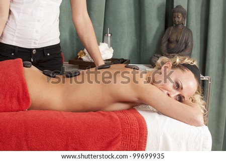 Therapy with hot stones on the back of a woman / Relax with hot stone