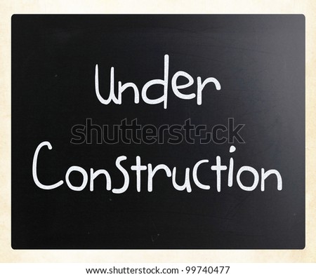 "Under construction" handwritten with white chalk on a blackboard