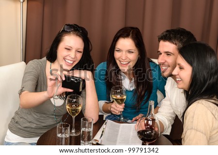 Cheerful young people enjoy drink after work at restaurant