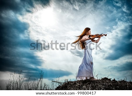 The red-haired girl with a violin outdoor Royalty-Free Stock Photo #99800417