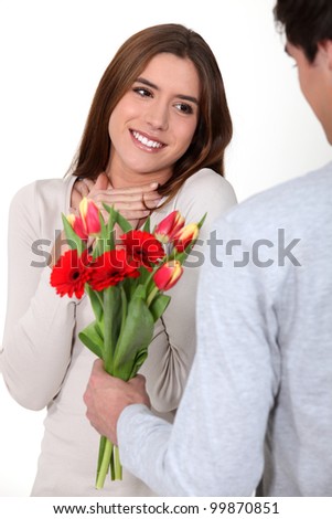 young romantic guy offering his belle flowers