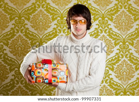 retro hip young man glasses holding  psychedelic gift box on wallpaper