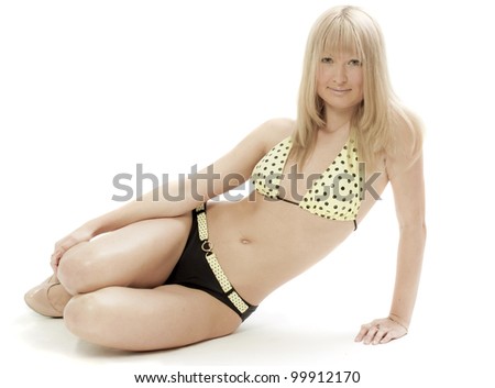 The girl in a bathing suit sits on a white background
