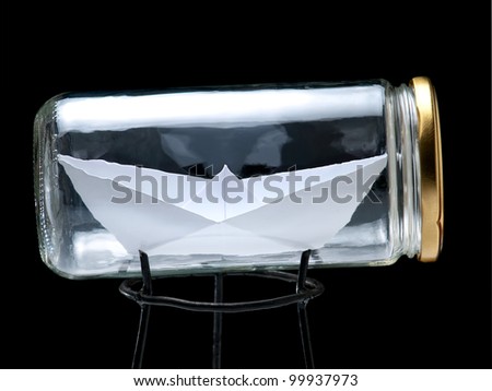 Paper ship in the jar on a black background.