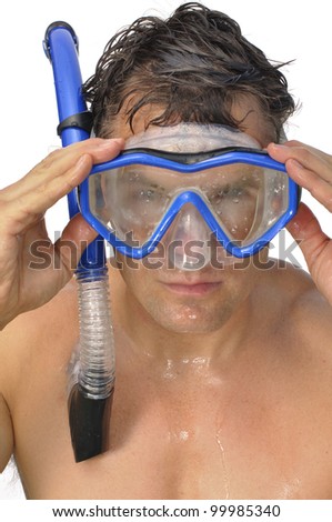 Wet male snorkeler adjusts mask while looking ahead