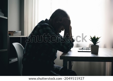 Image of 60s lonely Asian elderly man sitting at home, elderly self-isolate, sad, depressed during Covid-19