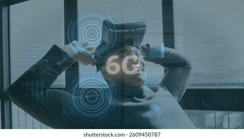 Image of 6g text, scopes scanning and data processing over smiling man wearing vr headset. global networking, technology and digital interface concept digitally generated image.