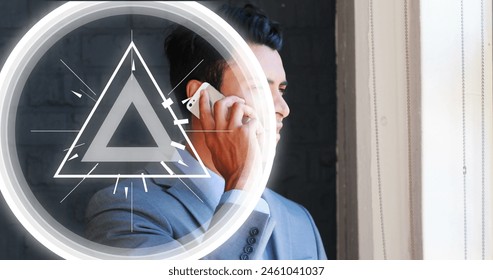 Image of abstract triangular shape pulsating over biracial businessman talking on smartphone. Global networking and business technology concept