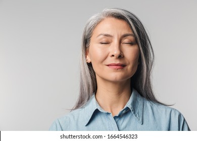 Image of adult mature woman with long white hair wearing shirt standing with eyes closed isolated over gray background