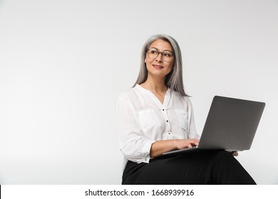 Image Of Adult Mature Woman Wearing Eyeglasses And Office Clothes Using Laptop Computer Isolated Over White Background