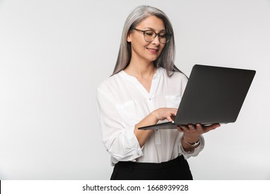 Image Of Adult Mature Woman Wearing Eyeglasses And Office Clothes Using Laptop Computer Isolated Over White Background