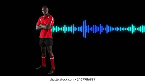 Image of african american male athlete standing arms crossed over soundwave on black background. Digital composite, multiple exposure, illuminated, competition, abstract and sports concept. - Powered by Shutterstock