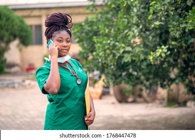 Image Of African Nurse Communicating On Phone After Her Shift At Work-black Health Worker With Envelope And Stethoscope-student Nurse Having Conversation On Phone After Work-beautiful Black Nurse