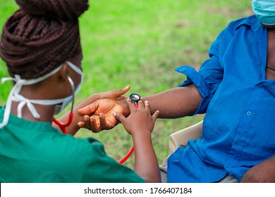 Image Of African Nurse Taking Care Of A Patient In A Home-aged Black Man And A Health Worker-young African Nurse Checking Pressure  