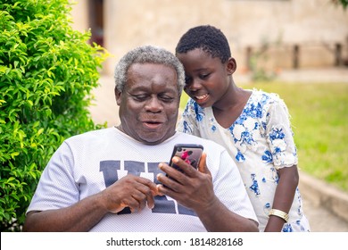image of African old man and young girl, with smart phone-outdoor concept