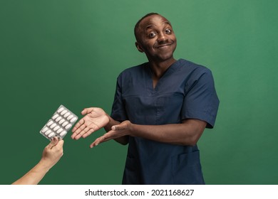 Image Of African Young Doctor, Therapeutic Or Medical Advisor Isoalted On Green Background. Concept Of Healthcare, Care, Medicine And Humor. Copy Space For Ad, Design. Looks Attentive, Happy