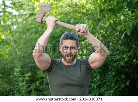 image of aggressive man with axe. aggressive man with axe. aggressive man with axe wearing shirt.