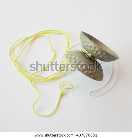 image of aluminum yoyo with anodized finish with fluorescent yellow string laying on a pedestal
