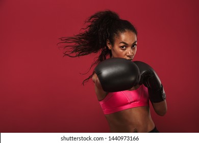 Image of amazing young african sports woman boxer posing isolated over red wall background make boxing exercises. - Powered by Shutterstock