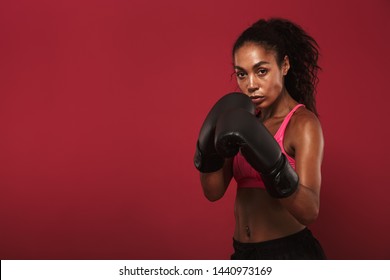 Image of amazing young african sports woman boxer posing isolated over red wall background make boxing exercises. - Powered by Shutterstock