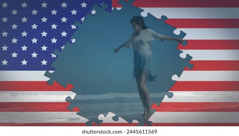 Image of American flag waving with jigsaw puzzles revealing woman dancing on beach by seaside on summer holiday in the background. American society diversity concept digital composition. - Powered by Shutterstock