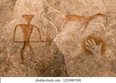 Image Of An Ancient Man With A Gun, An Animal, A Palm Print On The Cave Wall. 