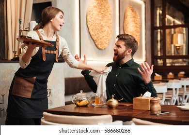 Image Of Angry Screaming Bearded Young Man Sitting In Cafe. Looking At Waiter.