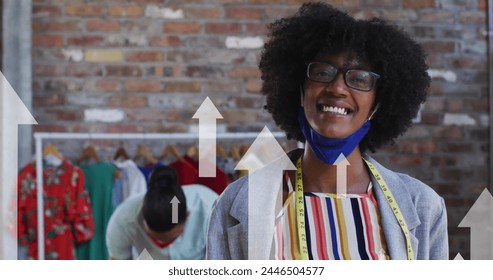 Image of arrows over diverse fashion designers working in face masks. global networks, business and connections during covid 19 pandemic concept digitally generated image. imation - Powered by Shutterstock