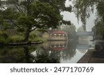 Image of Ashley Terrace Boathouse in Edinburgh Union Canal on a foggy day with two old rowing boats